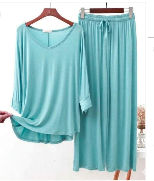 Turquoise pajama set on hangers with a white background